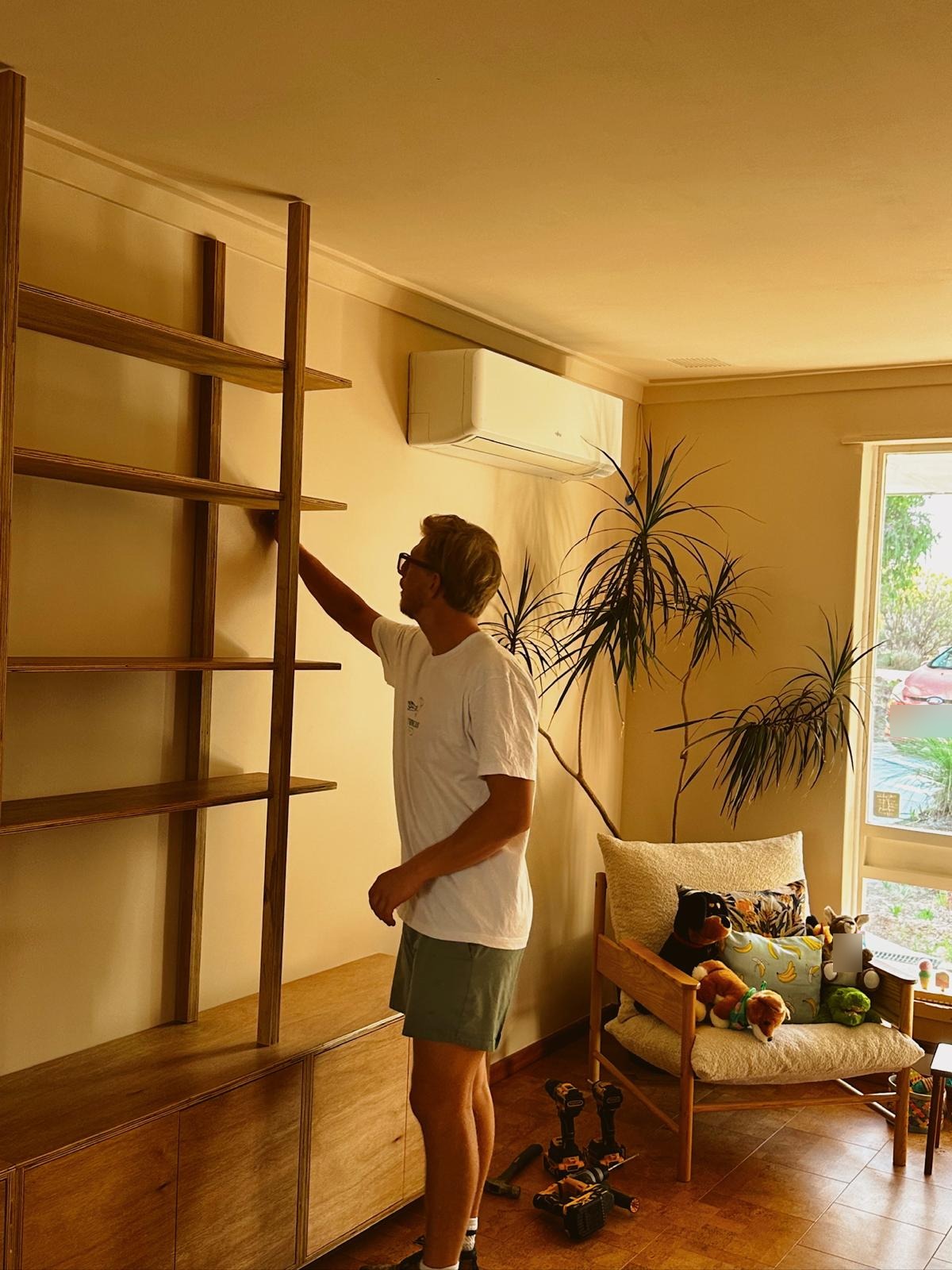Installing a floor-to-ceiling plywood bookcase above a low storage cabinet