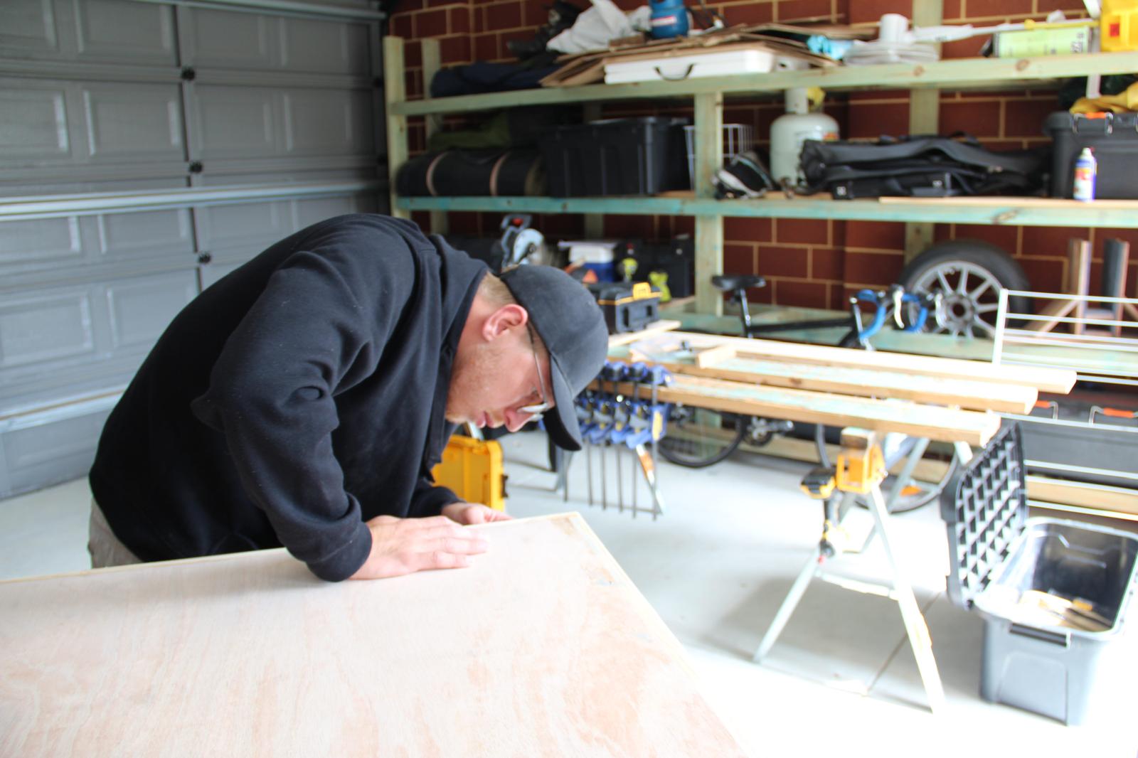 Joiner checking the solid timber edging on an unfinished plywood cabinet top