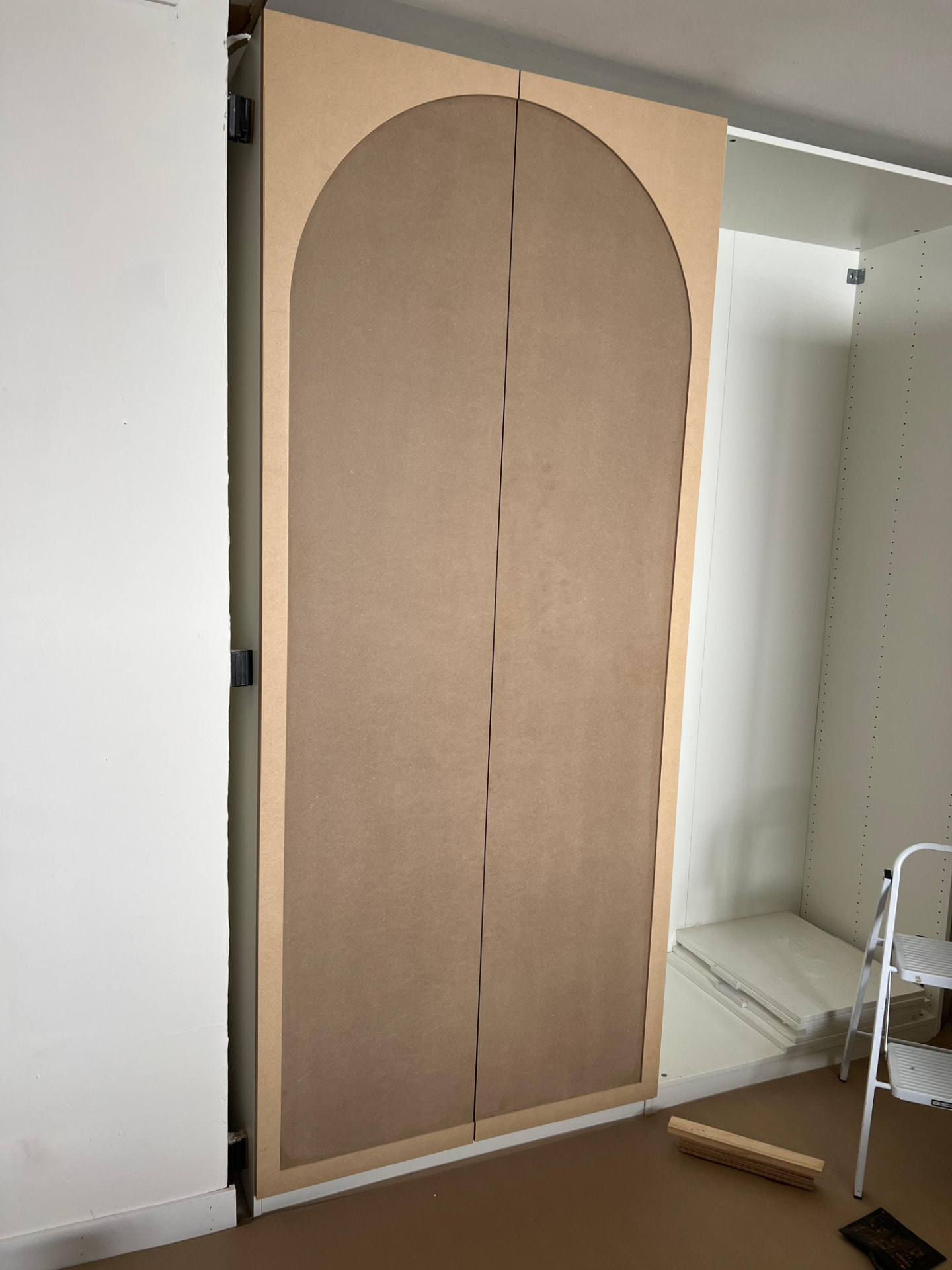 Pair of arch-detailed wardrobe doors fitted, before finishing